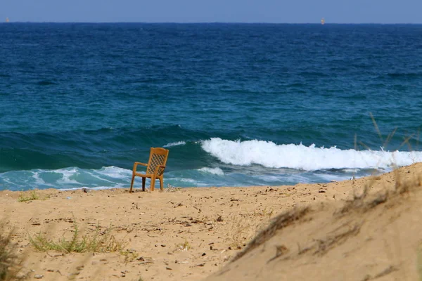 a chair stands on the shores of the Mediterranean Sea in the north of Israel