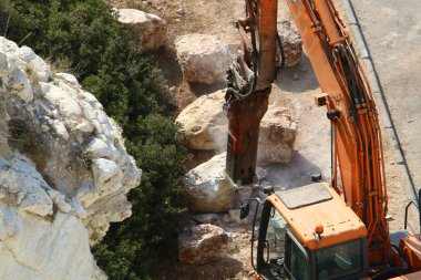 Büyük bir ekskavatör Akdeniz kıyısında İsrail'de bir şantiyede çalışır 