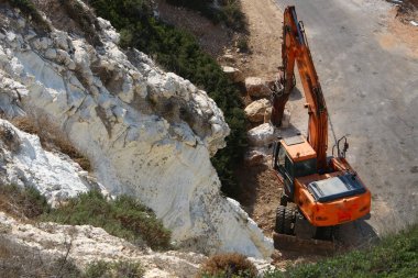 Büyük bir ekskavatör Akdeniz kıyısında İsrail'de bir şantiyede çalışır 
