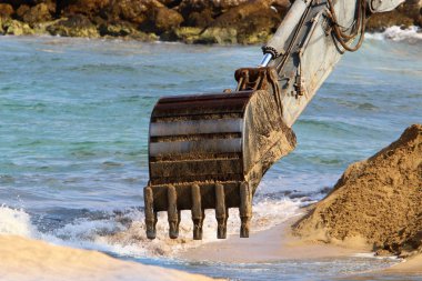 Büyük bir ekskavatör Akdeniz kıyısında İsrail'de bir şantiyede çalışır 