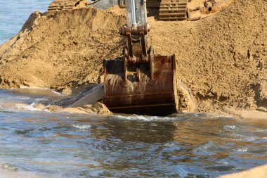 Büyük bir ekskavatör Akdeniz kıyısında İsrail'de bir şantiyede çalışır 