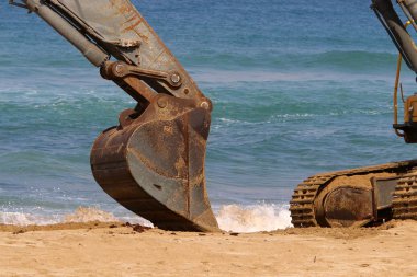 Büyük bir ekskavatör Akdeniz kıyısında İsrail'de bir şantiyede çalışır 