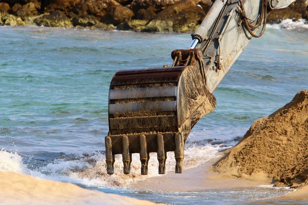 Büyük bir ekskavatör Akdeniz kıyısında İsrail'de bir şantiyede çalışır 