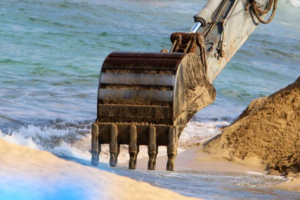 Büyük bir ekskavatör Akdeniz kıyısında İsrail'de bir şantiyede çalışır 