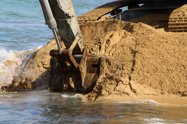 Büyük bir ekskavatör Akdeniz kıyısında İsrail'de bir şantiyede çalışır 