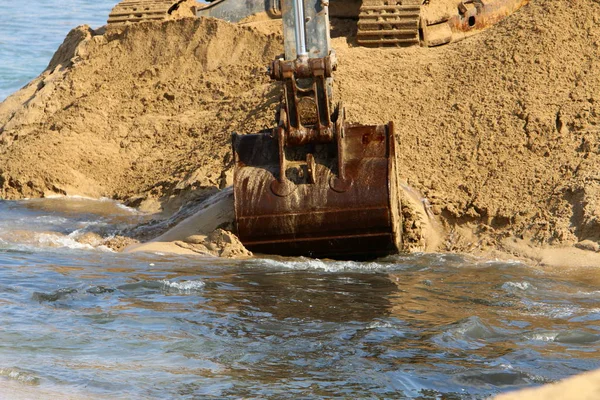 Büyük bir ekskavatör Akdeniz kıyısında İsrail'de bir şantiyede çalışır 