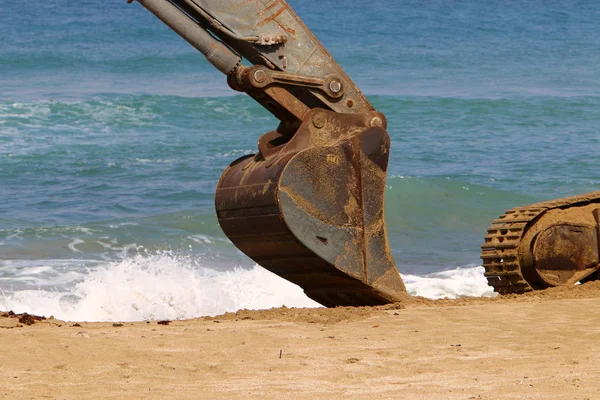 Büyük bir ekskavatör Akdeniz kıyısında İsrail'de bir şantiyede çalışır 