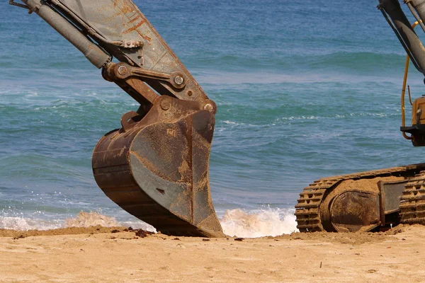 Büyük bir ekskavatör Akdeniz kıyısında İsrail'de bir şantiyede çalışır 