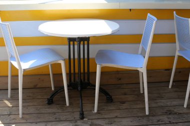 Bir sandalye ve dinlenmek için bir masa Kuzey İsrail'de Akdeniz kıyısında bir kafede duruyor 