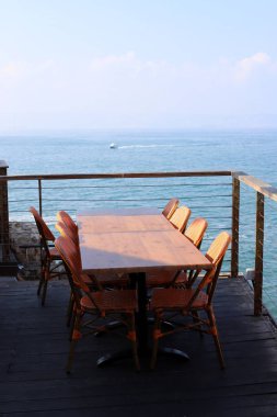 Bir sandalye ve dinlenmek için bir masa Kuzey İsrail'de Akdeniz kıyısında bir kafede duruyor 