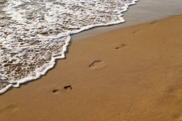 footprints in the sand on the shores of the Mediterranean Sea in the north of Israel