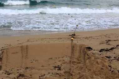 Izin verilen yüzme alanı korumak için İsrail devletinin kuzeyinde bir plajda bir ip 