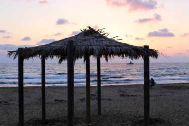 İsrail'in kuzeyinde Akdeniz kıyılarında sıcak güneşten korunmak için gölgelik 