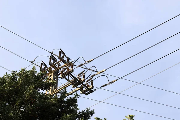 Electric wires on a pole along which electricity flows. Birds sit on electric wires