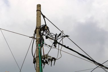 Elektrik kabloları elektrik akışını sağlayan bir direğe bağlı. Kuşlar elektrik kablolarına oturur. 