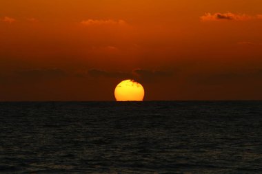 Gün batımında ufukta ateş gibi kırmızı bir gökyüzü beliriyor. Kuzey İsrail 'deki Akdeniz' de güneş ufuktan batıyor. 