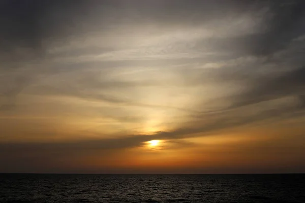 Fiery red sky lighting over the horizon at sunset. The sun sets over the horizon in the Mediterranean Sea in northern Israel