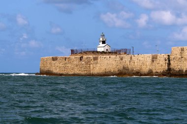 Akdeniz kıyısındaki eski deniz feneri Kuzey İsrail 'deki Acre şehrinde. 