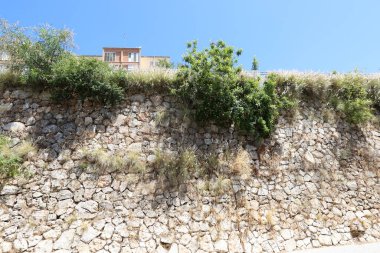 Taş ve betondan yapılmış yüksek duvar. Taş duvar dokusu 