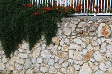Taş ve betondan yapılmış yüksek duvar. Taş duvar dokusu 