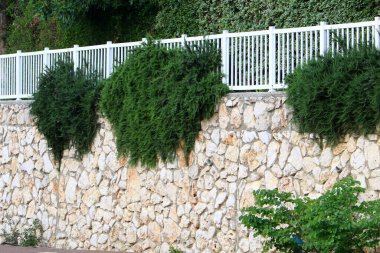 Taş ve betondan yapılmış yüksek duvar. Taş duvar dokusu 