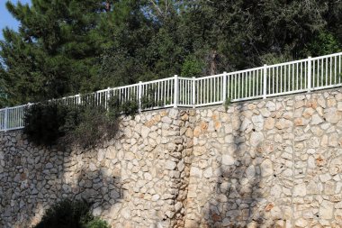 Taş ve betondan yapılmış yüksek duvar. Taş duvar dokusu 