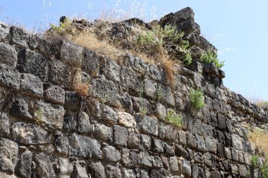 Taş ve betondan yapılmış yüksek duvar. Taş duvar dokusu 