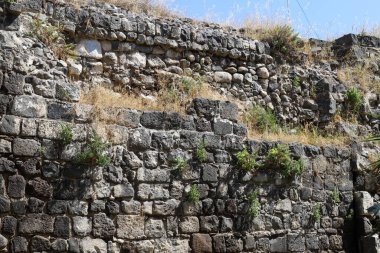 Taş ve betondan yapılmış yüksek duvar. Taş duvar dokusu 