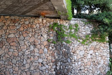 Taş ve betondan yapılmış yüksek duvar. Taş duvar dokusu 