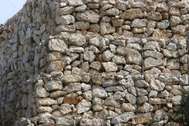 Taş ve betondan yapılmış yüksek duvar. Taş duvar dokusu 