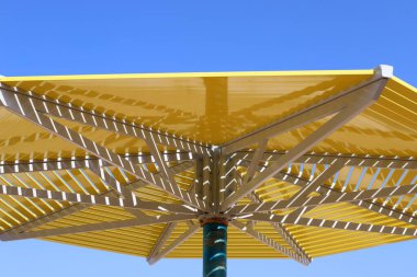 İsrail 'de deniz kenarındaki bir parktaki sıcak güneşten bir gölgelik. İsrail 'de sıcak yaz 