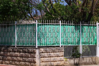 Ağaçlar ve çiçekler İsrail 'de bir şehir parkında çit boyunca yetişir. 