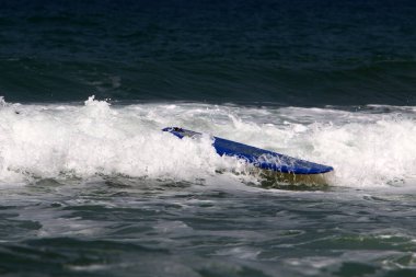 Sporcu özel bir sörf tahtası üzerinde deniz dalgalarının tepesinde süzülür. İsrail açıklarında Akdeniz 'de fırtına var. 