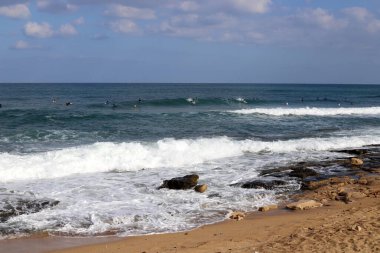 Sporcu özel bir sörf tahtası üzerinde deniz dalgalarının tepesinde süzülür. İsrail açıklarında Akdeniz 'de fırtına var. 