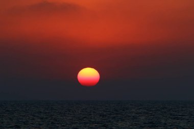 Gün batımında ufukta gökyüzünün parlak kırmızı ışığı. Kuzey İsrail 'de Akdeniz' de Günbatımı 