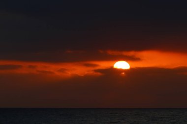 Gün batımında ufukta gökyüzünün parlak kırmızı ışığı. Kuzey İsrail 'de Akdeniz' de Günbatımı 
