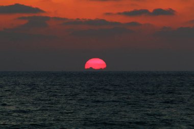 Gün batımında ufukta gökyüzünün parlak kırmızı ışığı. Kuzey İsrail 'de Akdeniz' de Günbatımı 