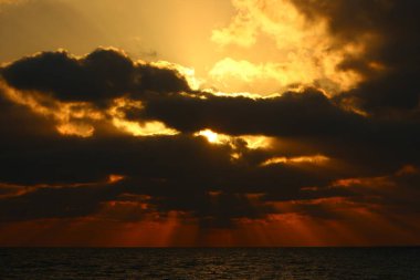 Gün batımında ufukta gökyüzünün parlak kırmızı ışığı. Kuzey İsrail 'de Akdeniz' de Günbatımı 