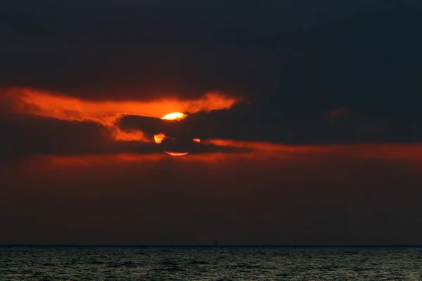 Fiery red illumination of the sky above the horizon at sunset. Sunset on the Mediterranean Sea in northern Israel