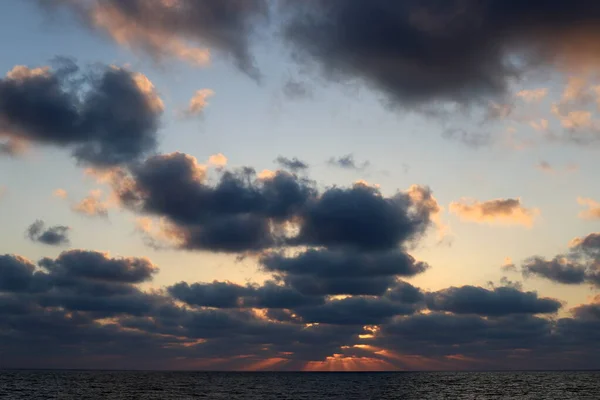 Fiery red illumination of the sky above the horizon at sunset. Sunset on the Mediterranean Sea in northern Israel