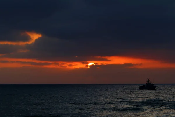 Fiery red illumination of the sky above the horizon at sunset. Sunset on the Mediterranean Sea in northern Israel