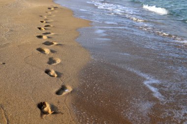 Akdeniz kıyısındaki kumda ayak izleri. Kuzey İsrail 'deki kumlu sahil 