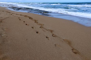 Akdeniz kıyısındaki kumda ayak izleri. Kuzey İsrail 'deki kumlu sahil 