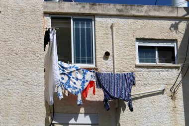 Pencere ve balkonlarda çamaşır ipleri kuruyor. İsrail 'deki konutların mimari detayları 