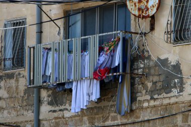 Pencere ve balkonlarda çamaşır ipleri kuruyor. İsrail 'deki konutların mimari detayları 