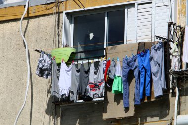 Pencere ve balkonlarda çamaşır ipleri kuruyor. İsrail 'deki konutların mimari detayları 