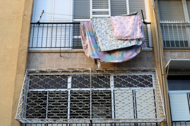 Pencere ve balkonlarda çamaşır ipleri kuruyor. İsrail 'deki konutların mimari detayları 