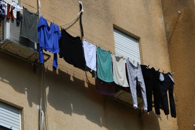 Pencere ve balkonlarda çamaşır ipleri kuruyor. İsrail 'deki konutların mimari detayları 