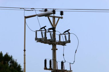 İsrail 'de mavi gökyüzüne karşı yalıtkan ve elektrik kablolarıyla metal destek direği 