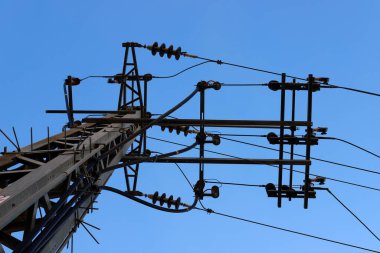 İsrail 'de mavi gökyüzüne karşı yalıtkan ve elektrik kablolarıyla metal destek direği 